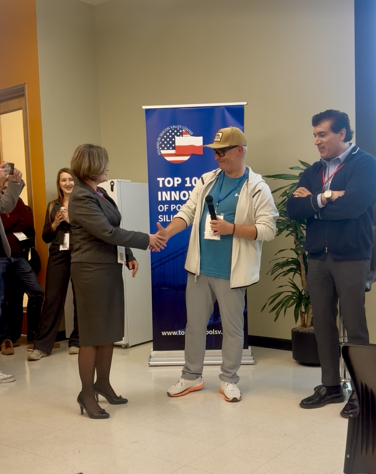 Kobieta podaje rękę mężczyźnie z mikrofonem